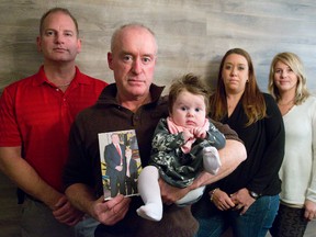 John Curry, centre, holds his three-month old daughter, Autumn, and a photo of his older brother Paul with his son Tyler. Paul Curry was murdered Sept. 16, 2013 by their nephew Shane Wood, who faces his sentencing Tuesday. With John Curry is John Handley, one of Paul Curry?s best friends, niece Colleen Marsh and his wife Amy Houston. (CRAIG GLOVER, The London Free Press)