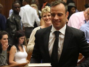 Oscar Pistorius, centre, leaves a courtroom of the High Court in Pretoria, South Africa, Tuesday Dec. 8, 2015. (AP Photo/Siphiwe Sibeko, Pool)