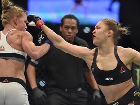 Holly Holm (left) deflects a punch from Ronda Rousey during their UFC bantamweight title fight in Melbourne on November 15, 2015. (AFP PHOTO/Paul CROCK)
