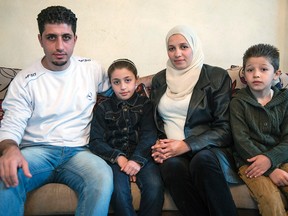 Syrian refugee Emad Alhajali, from Kherbet Ghazalah, Syria sits with his daughter Fatma, 8, his wife Razan and son Mohammand in the family apartment Monday, November 30, 2015 in Irbid. The family is waiting for approval to immigrate to Canada.