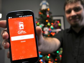 Kyle Mayer, marketing manager for London software developer CoreSolutions, holds a smartphone displaying the company’s Gifts app in London Ont. December 3, 2015. CHRIS MONTANINI\LONDONER\POSTMEDIA NETWORK