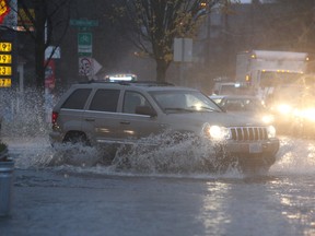 Pouring rain and clogged storm drains caused flooding in the streets near the  corner of SE 12th and Hawthorne in Portland, Ore., Monday, Dec. 7, 2015.  (Dave Killen/The Oregonian via AP)