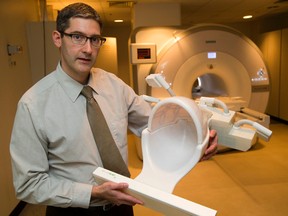 Dr. Jean Theberge holds up a coil that he designed that allows research grade images to be made of the brain for neuro-pyschiatry at the Lawson Research Institute at St. Joseph's Health Centre in London, Ont. on Tuesday December 8, 2015. (MIKE HENSEN, The London Free Press)