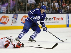 Maple Leafs defenceman Dion Phaneuf (3) tries to keep the puck in the zone as Devils forward Lee Stempniak (20) lies on the ice during second period NHL action in Toronto on Tuesday, Dec. 8, 2015. (John E. Sokolowski/USA TODAY Sports)
