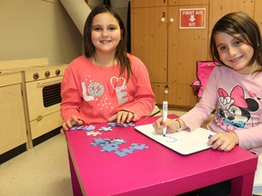 BRUCE BELL/The Intelligencer
Cia (left) and Abby Speirs enjoy a few minutes of play time during the family holiday dinner at Reaching for Rainbows at St. Andrew's Presbyterian Church in Picton. The Picton sisters are two of the participants in the popular after-school program for young girls.