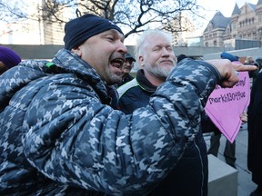 A pro-Uber man walks into cab protesters  before being taken away by police in front of city hall on Wednesday December 9, 2015. Michael Peake/Toronto Sun/Postmedia Network