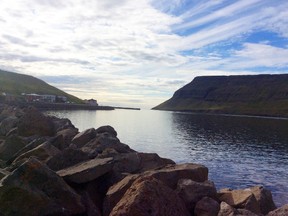 This Aug. 8, 2015 photo shows an imposing headland marking the head of the fjord leading to Sudureyri, Iceland. The fishing village has only about 500 people, but plays host to a summer theater festival popular among language students innearby Isafjordur. (AP Photo/Jim Heintz)