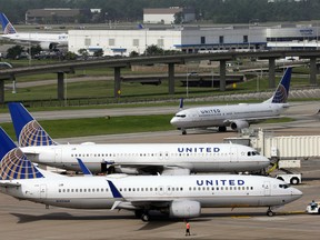 In this July 8, 2015, file photo, a United Airlines plane, front, is pushed back from a gate at George Bush Intercontinental Airport in Houston. United Airlines reports quarterly financial results on Thursday, July 23, 2015. (AP Photo/David J. Phillip, File)