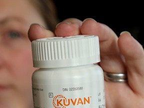 Tanya Compeau holds a jar of the drug Kuvan. (Ian MacAlpine/The Whig-Standard)