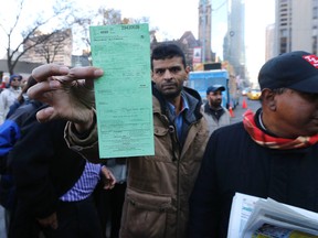 Toronto cab protesters show a ticket one of them received in front of City Hall onDec. 9, 2015. (Michael Peake/Toronto Sun)