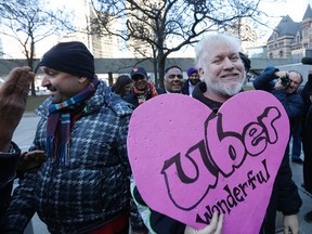 A pro-Uber man walks into cab protesters before being taken away by police in front of City Hall on Dec. 9, 2015. (Michael Peake/Toronto Sun)