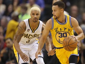 Warriors guard Stephen Curry (right) is guarded by Pacers guard George Hill (left) during NBA action in Indianapolis on Dec. 8, 2015. (Brian Spurlock/USA TODAY Sports)