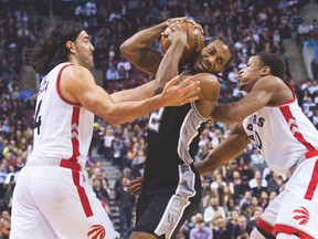 Raptors forward Luis Scola (left) combines with teammate DeMar DeRozan to provide defence against Kawhi Leonard of the Spurs last night at the ACC. (Nathan Denette, The Canadian Press)