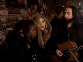A still image from a video shows singer Madonna (C) giving an impromptu street concert at the Place de la Republique in Paris December 10, 2015, the site of massed tributes for the victims of the recent Paris attacks.REUTERS TV