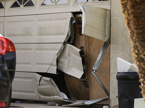 A garage door of Enrique Marquez's home is seen broken in a recent FBI raid, Wednesday, Dec. 9, 2015, in Riverside, Calif.  (AP Photo/Jae C. Hong)