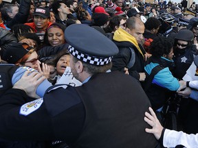 A pushing match between Chicago police officers and protesters erupts during a march calling for Chicago mayor Rahm Emanuel and Cook County State's Attorney Anita Alvarez to resign in the wake of a police scandal, Wednesday, Dec. 9, 2015, in Chicago. (AP Photo/Charles Rex Arbogast)