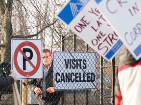 An employee at the Ottawa-Carleton Detention Centre puts up a "visits cancelled" sign as correctional officers stand on the picket line out front of the Innes Rd. jail on Thursday, Dec. 10, 2015.
MATT DAY/OTTAWA SUN