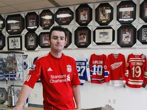 Mark Madeley stands by the counter in his new store, Competitive Edge Sports. Madeley sells sports memorabilia such as jerseys, signed photos and replica rings at his store, which opened its doors on Nov. 14. (Julia McKay/The Whig-Standard)