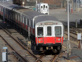 A passenger train moves slowly along tracks in a railway yard, Thursday, Dec. 10, 2015, in Boston. The six-car train with passengers on board left a suburban Boston transit station without a driver Thursday and went through four stations without stopping was tampered with, Massachusetts Gov. Charlie Baker said. (AP Photo/Steven Senne)