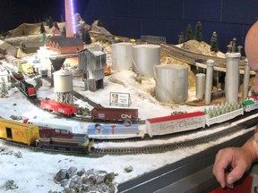 Bob Farquhar, one of the volunteers helping put on a holiday train show at the Pump House Steam Museum in Kingston, watches a couple of trains go by on one of the layouts on Thursday. (Michael Lea/The Whig-Standard)