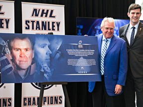 Glen Sather, left, and Edmonton mayor Don Iveson stand next to an announcement that the Oilers Community Foundation and Daryl Katz are contributing $1 million to the Downtown Community Arena during a public ceremony honouring former Edmonton Oilers coach and general manager Glen Sather at the Winspear Centre in Edmonton, Alta., on Thursday, Dec. 10, 2015. Codie McLachlan/Edmonton Sun