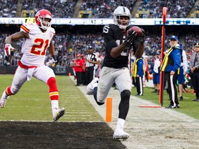 Raiders wide receiver Michael Crabtree (right) catches the ball but is unable to stay in bounds ahead of Chiefs cornerback Sean Smith (left) during third quarter NFL action in Oakland on Dec. 6, 2015. (Kelley L Cox/USA TODAY Sports)