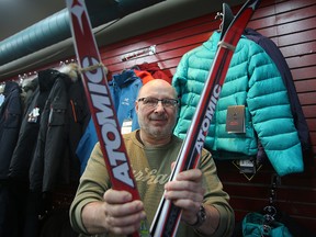 Brian Burke, owner of Olympia Cycle and Ski, holds skis in his shop in Winnipeg, Man. Thursday December 10, 2015. Burke is happy that snow is arriving bringing with it a boost in sales of skis and related items.