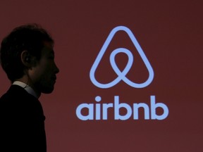 A man walks past a logo of AirBnB. (REUTERS/Yuya Shino)