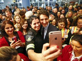 Prime Minister Justin Trudeau poses with airport staff as they await Syrian refugees to arrive at Toronto Pearson International Airport December 10, 2015. (REUTERS/Mark Blinch)