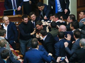 Ukrainian lawmakers fight each other following Prime Minister Arseniy Yatsenuk's speech during a parliamentary session in Kiev, Ukraine, on Dec. 11, 2015. (AP Photo/Sergei Chuzavkov)
