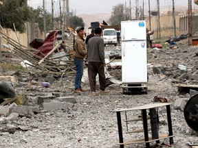 Yazidi people loot the houses in the town of Sinjar, Iraq November 16, 2015. Before it was overrun by Islamic State, Sinjar and the surrounding villages were home to about 200,000 people, mainly Kurdish and Arab Muslims - both Sunni and Shi'ite - as well as Christians and Yazidis, a faith that combines elements of several ancient Middle Eastern religions. Now the town is largely deserted. REUTERS/Azad Lashkari