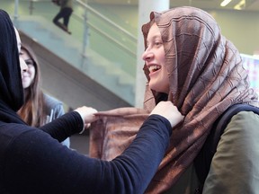Reesha Ahmed-Khan, member of the Women's Auxiliary of the Ahmadiyya Muslim Community in Kingston, shows Cecily Blake, a fourth-year psychology student at Queen's University, how to properly wear a hijab. (Steph Crosier/The Whig-Standard)