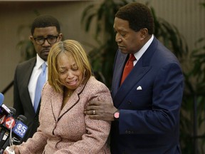 Attorney John Burris, right, comforts Gwen Woods, the mother of Mario Woods, the a knife-wielding stabbing suspect who was fatally shot by San Francisco Police last week, at a news conference at Southeast Community College in San Francisco, Friday, Dec. 11, 2015. (AP Photo/Jeff Chiu)