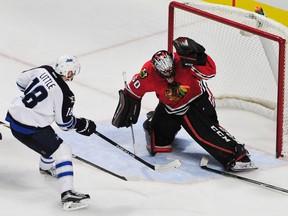 Chicago Blackhawks goalie Corey Crawford (50) makes a save on Winnipeg Jets center Bryan Little (18) during the third period at the United Center. The Blackhawks won 2-0. David Banks-USA TODAY Sports