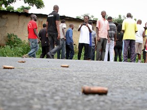 A man looks across at spent bullet casings lying on a street in the Nyakabiga neighborhood of Bujumbura, Burundi, Saturday, Dec. 12, 2015. Burundi's political violence continued Saturday as a number of people were found shot dead in the Nyakabiga neighborhood of the capital, a day after the government said an unidentified group carried out coordinated attacks on three military installations. (AP Photo)