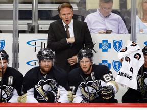 In this Sept. 22, 2015,  file photo Pittsburgh Penguins head coach Mike Johnston, center, stands behind Sidney Crosby, and Phil Kessel during an exhibition NHL hockey game against Carolina Hurricanes in Pittsburgh. (AP Photo/Gene J. Puskar, File)