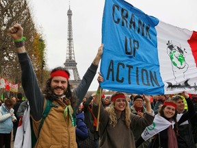 Environmentalists hold a banner which reads, "Crank up the Action" at a protest demonstration near the Eiffel Tower in Paris, France, as the World Climate Change Conference 2015 (COP21) continues near the French capital in Le Bourget, December 12, 2015.  REUTERS/Mal Langsdon