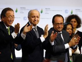 French President Francois Hollande, right, French Foreign Minister and president of the COP21 Laurent Fabius, center, and United Nations Secretary General Ban ki-Moon applaud after the final conference at the COP21, the United Nations conference on climate change, in Le Bourget, north of Paris, on Dec.12, 2015. (AP Photo/Francois Mori)