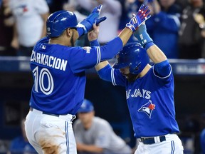 Toronto Blue Jays' Edwin Encarnacion and Jose Bautista celebrate at home plate after scoring against the Kansas City Royals during Game 5 of the American League Championship Series in Toronto on Oct. 21, 2015. (THE CANADIAN PRESS/Nathan Denette)
