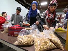 A farmer donated 1.8 tons of chick peas to the food bank and the volunteers from Islamic Family Social Services Association help bag the peas. at the Food Bank in Edmonton, Alberta on December 12, 2015. Perry Mah/Edmonton Sun/Postmedia Network