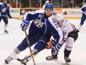 Sudbury Wolves'  Kyle Capobianco, left,  muscles his way past the Owen Sound Attack's Justin Brack during Ontario Hockey League action at the Lumley Bayshore in Owen Sound, Ont. on Saturday, December 12, 2015.  James Masters/Postmedia Network