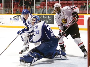 Owen Sound's Jaden Lindo (right) looks on as Sudbury's Troy Timpano (front) makes a save in front of Wolves' defenseman Zach Wilkie in the Attack's 5-3 win on Saturday in Ontario Hockey League action.