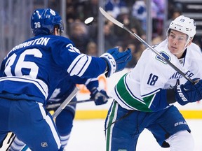 Vancouver Canucks right wing Jake Virtanen (18) flips the puck in the air past Toronto Maple Leafs defenceman Scott Harrington (36) in Toronto on November 14, 2015. Whether Virtanen will be loaned to the Canadian team for the world junior tournament may become known on Sunday. (THE CANADIAN PRESS/Nathan Denette)