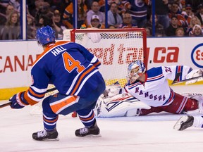 Edmonton forward Taylor Hall (4) scores on New York goaltender Antti Raanta (32) during the third period of a NHL game between the Edmonton Oilers and the New York Rangers at Rexall Place in Edmonton, Alta. on Friday December 11, 2015. Former Oilers coach Glen Sather's number was retired during a ceremony before the game. Ian Kucerak/Edmonton Sun/Postmedia Network