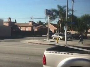 A Los Angeles County Sheriff's deputy points his gun at an armed suspect Saturday, Dec. 12, 2015. (Framegrab)