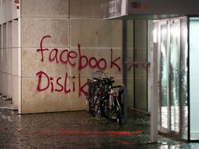 In this Dec. 12,  2015 picture bicycles stand next to a destroyed  entrance of  a building that was attacked  in Hamburg , northern Germany.  Police say they are looking for a group of up to 20 people who wrote "Facebook Dislike" on the social media firm's German headquarters in Hamburg.   (Bodo Marks/dpa via AP)