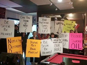 People in Sylvan Lake, AB hold up protest signs as they prepare for the Stand Up For AB: Be Seen, Be Heard rally in the central Alberta town next weekend. PHOTO SUPPLIED