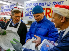 Chris Bailey, pictured with Mayor John Tory (left) and David Mirvish (right), waited 24 hours so he could get his hands on the first bird handed out at Honest Ed’s. (DAVE THOMAS, Toronto Sun)