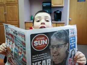Ten-year-old Prescott resident Blair Brewer reads a copy of the Ottawa Sun at Wellington Elementary School on Tuesday, Dec. 12, 2015. A cognitive impairment has made learning to read hard for the fifth-grader but his love for reading about hockey has had a big impact on his literacy. 
Chris Hofley/Ottawa Sun