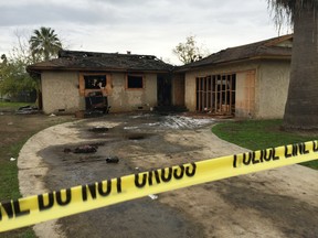 An abandoned house where multiple people died early Sunday, Dec. 13, 2015 in Fresno, Calif., is seen after flames were extinguished. The Fresno Fire Department says fire crews brought several people out of the boarded-up home. (Paul Schlesinger/The Fresno Bee via AP)